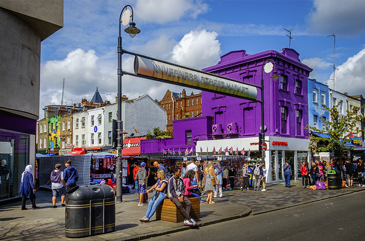 Edificios, cartel y gente en el mercadillo callejero Inverness en Camden Town